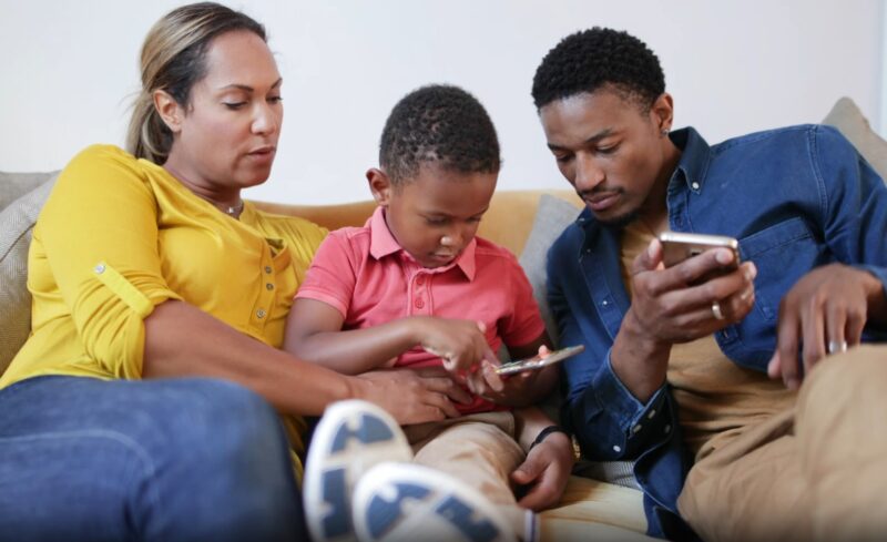 family sitting on couch and holding phones