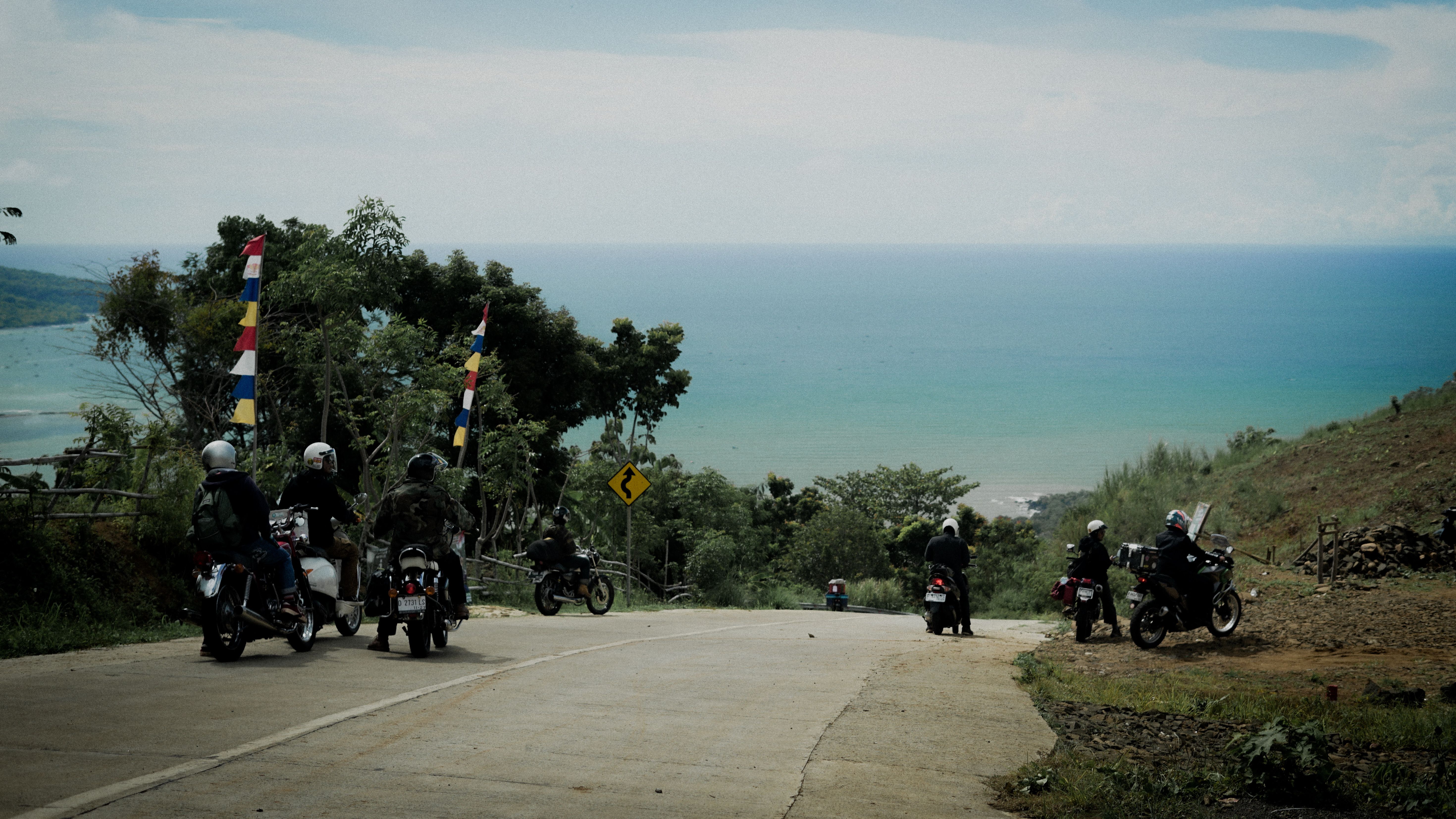 Group of motorcyclists riding together on a rural road beside the sea on a Gulf Coast ride